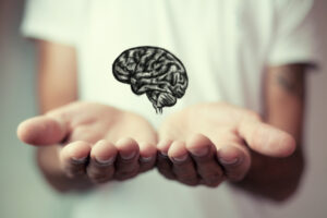 man holds an illustration of a brain